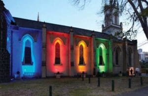 Church building lit with colorful lights.