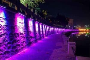 Purple lights illuminate a stone wall.