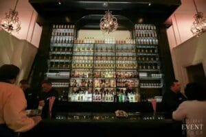 Bar with a liquor shelf and patrons.