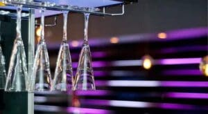 Empty champagne glasses hanging in bar.